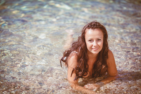 躺在海边的湿头发的年轻女子