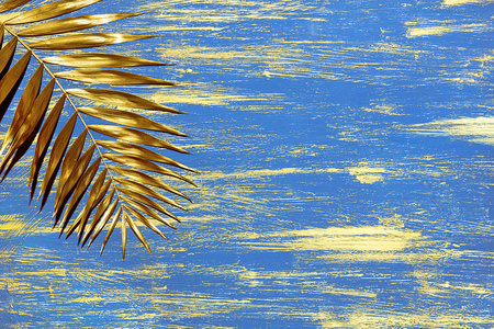 金色棕榈树枝装饰彩绘蓝色背景与金色涂片