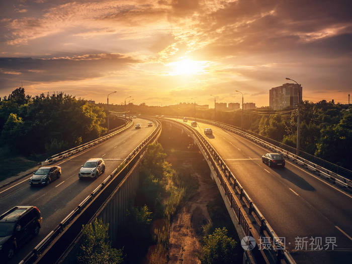城市交通汽车在日落行驶在高速公路上的城市景观夏季场景城市交通概念