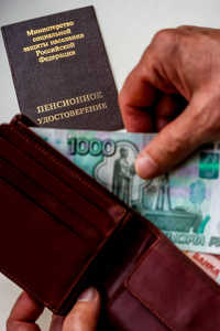 妇女的手持有钱包与俄罗斯卢布, 俄罗斯养老金证书的背景。俄罗斯翻译俄罗斯联邦人口社会保护部。养老金证书