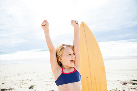 快乐年轻的女孩，在海滩上的冲浪板