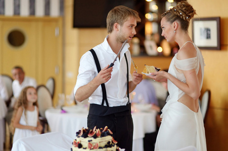 幸福的新娘和新郎切割他们的结婚蛋糕