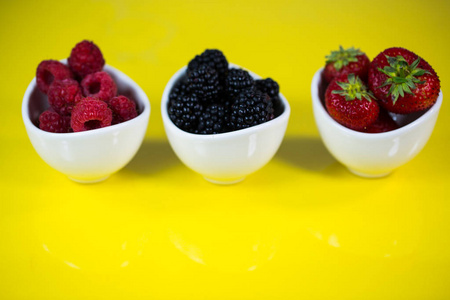 草莓, 黑莓和 rasberries 在碗里, 黄色背景