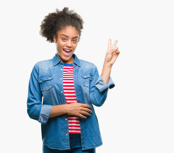 年轻的美国黑人妇女在独立背景微笑与愉快的面孔眨眼在照相机做胜利标志。第二个