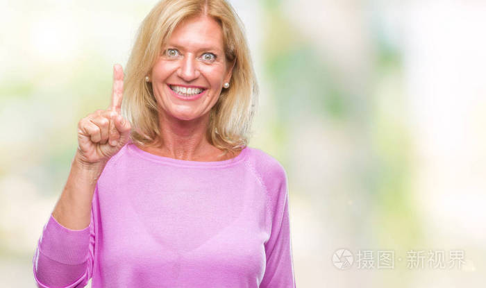 中年金发女人在孤立的背景显示, 并指出手指第一, 而微笑着自信和快乐