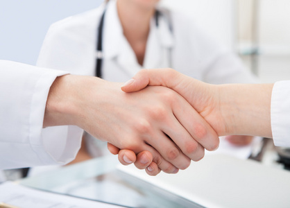 医生在桌前握手照片
