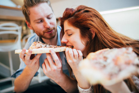 对夫妇分享比萨饼和愉快地一起吃饭