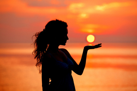 快乐自由的女人享受在海上日落。背着