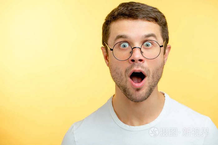 一个惊讶的家伙正在看摄影机.睁大眼睛的情绪人