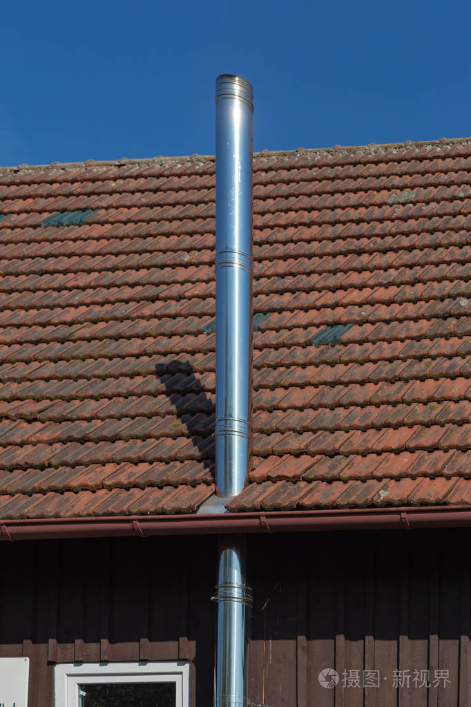 现代钢烟囱在农村建筑和蓝天晴朗的一天