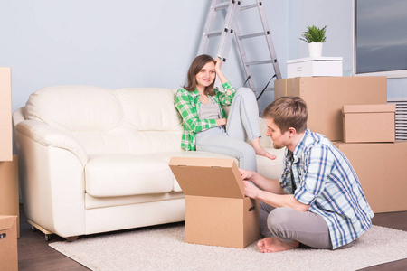 搬家, 新公寓和搬迁概念年轻人帮助他的妻子与拆开包装