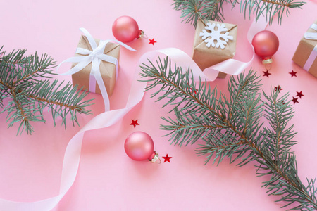 圣诞快乐, 新年愉快。圣诞贺卡与绿色杉木分行和假日对象在淡粉色背景上的节日