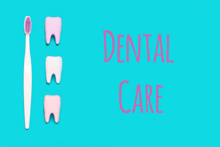 牙刷和大牙齿在蓝色和粉红色的背景。牙齿护理简约主义的概念。牙科护理文本
