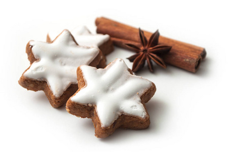 特写镜头的圣诞节饼干形状的明星与八角花和肉桂棒在白色背景