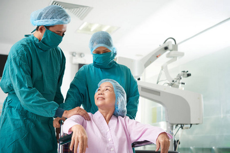 手术前护理成熟亚裔妇女的和蔼外科医生照片