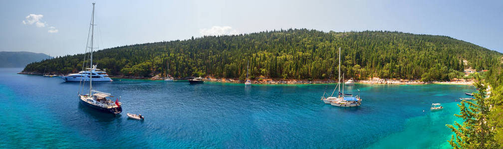 在希腊凯法利尼亚岛爱奥尼亚海的一个阳光明媚的日子里, 美丽的海滩和游艇上有清澈的绿松石水