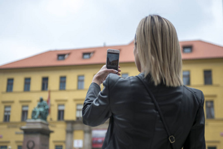 妇女游客拍照与移动摄像头在街上