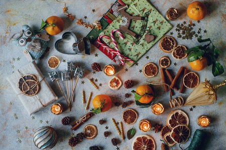 新年或圣诞节组合橘子, 干橙子, 肉桂, 礼物, 糖果和玩具在浅色乡村餐桌上