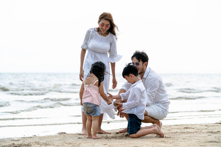快乐家庭的父亲, 母亲和孩子去度假在热带沙滩在夏天