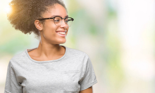 年轻的美国黑人妇女戴着眼镜在与世隔绝的背景下, 脸上带着微笑, 自然的表情。笑的自信