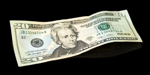 一个美元的钞票一堆面值为100美元的美元钞票卷起来,和一个简单的橡皮