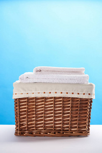 洗衣篮的特写镜头与干净的柔软的毛巾在蓝色
