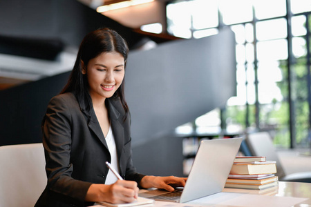 年轻的女商人努力工作照片