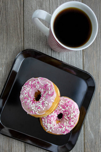 粉红色甜甜圈供应早餐与管道热咖啡