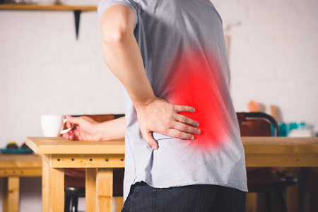 背部疼痛, 肾脏炎症, 男子在家背痛, 疼痛区域突出显示红色照片