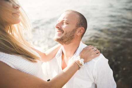 刚结婚的婚礼夫妇海滩上散步，在日落时分