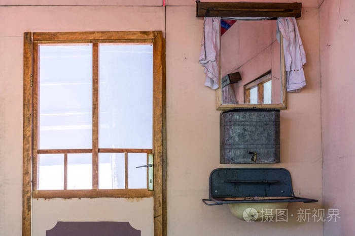 旧复古和老式的房子内部与门和非常旧的水箱水槽和水龙头.