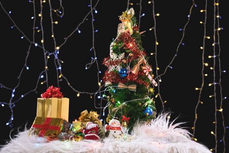 圣诞假期背景与装饰圣诞树, 圣诞老人和礼品盒黑色背景和圣诞灯。文本的新年框架