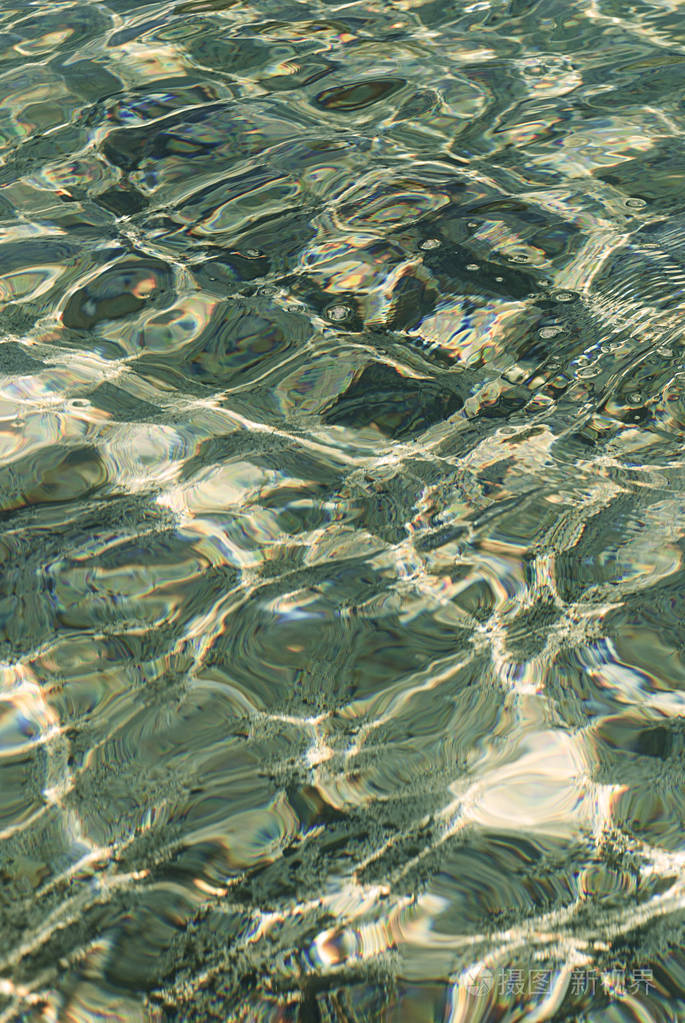 在有小波浪的清澈水中折射光线色调照片
