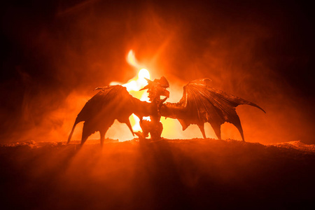 长途大吧性故事火呼吸龙的剪影与大翼在黑暗的燃烧的火背景.