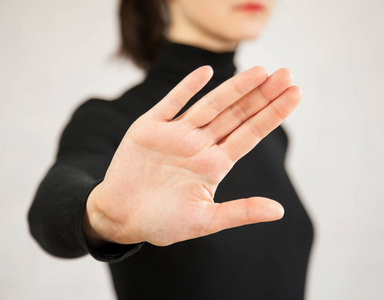 手势识别无法辨认的年轻女子演示拒绝手势, 中性背景照片