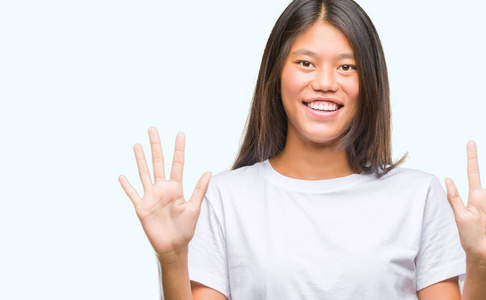 年轻的亚洲妇女在孤立的背景显示和指向手指数八, 而微笑着自信和快乐