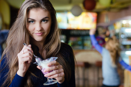 年轻快乐的女人，在咖啡馆吃冰激淋