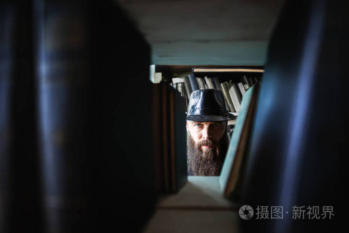 有胡子的人在书架上窥探神秘oncept