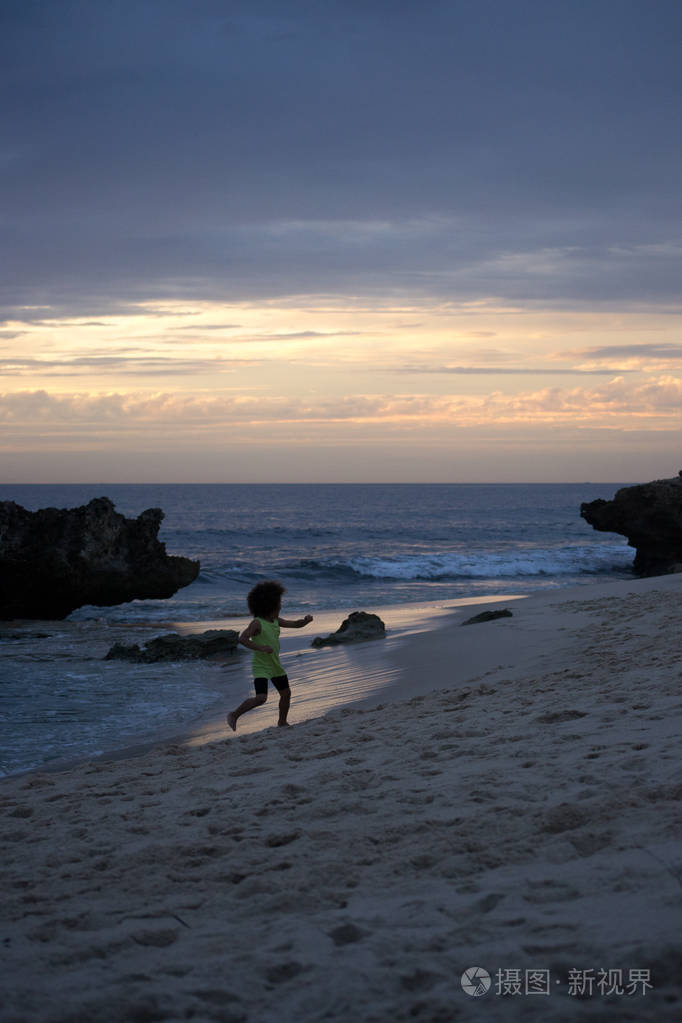 在海滩上玩日落的孩子