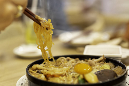 手用筷子吃日本乌冬面配鸡蛋
