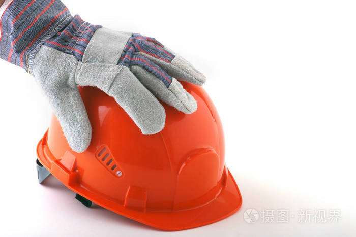 戴着防护手套的工人手里拿着一顶橙色的安全帽.安全帽