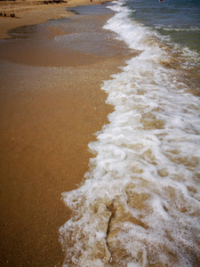 夏天的海滩和柔和的波浪过去。沙子和海