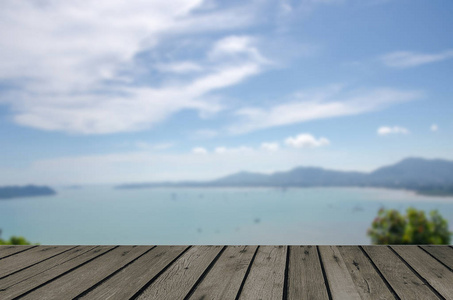 木桌顶部和抽象的蓝海景观模糊。可用于显示或蒙太奇您的产品