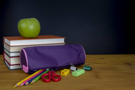 彩色钢笔, 箱子和书在黑板前面, 回到学校概念