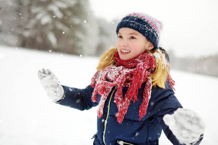 可爱的小女孩，美丽的冬季公园玩得开心。可爱的孩子在雪地里玩。孩子们的冬季活动