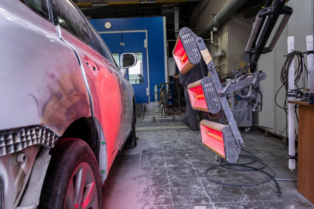 在工作环境中用红灯笼在车身修理店涂腻子和油漆后车身零件的红外干燥