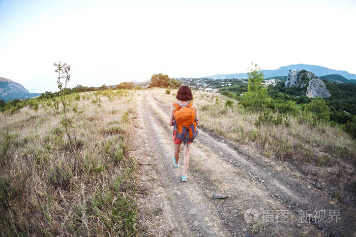 一个女人带着背包旅行.女孩爬到顶部.褐发女郎沿着山路走.鱼眼镜片