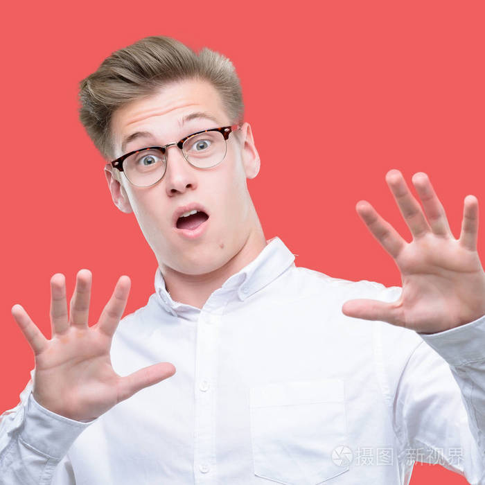 年轻英俊的金发男人害怕和惊恐的表情用手停止手势, 在震惊中大叫.