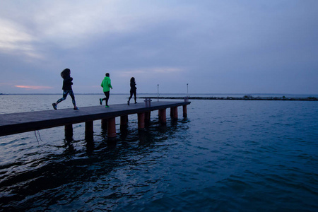 在户外训练的年轻人群体, 跑步者锻炼, 海洋或河流背景