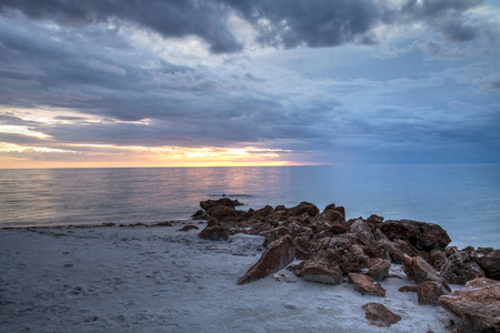 雨从乌云上倾泻而下, 在那不勒斯的海蛤湾海滩, 日落时分的佛罗里达